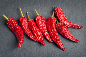 Red pepper. Dry peppers are spread out on a black slate stone. Hot chili peppers.