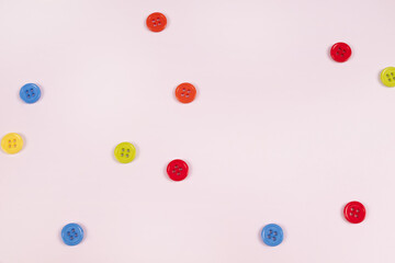multicolored buttons are randomly scattered over a white surface