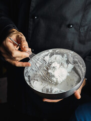 
Cook in black uniform whips the cream to the point of snow
Conceptual of food, gastronomy, pastry