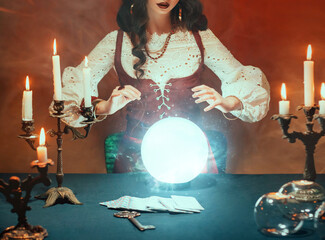 Fantasy retro women's hands close-up, witch feel energy magic of glowing crystal ball. dark gothic...