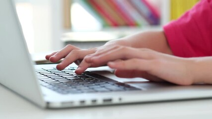 Little schooolgirl typing on laptop keyboard with two fingers, close up - Powered by Adobe