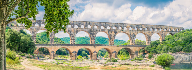 Recreation under the Pont du Gard ancient roman aqueduct during sunny day, France