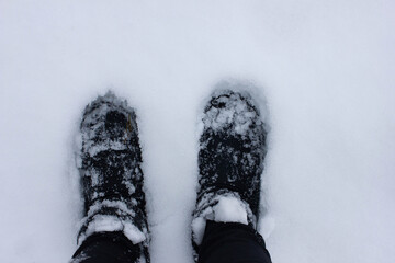 Winter shoe on feet sprinkled with snow on a cold frosty day
