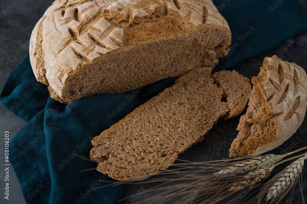 Wall mural homemade rye round bread on a dark background