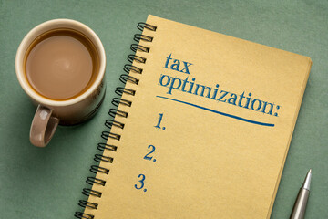 tax optimization list - handwriting in a notebook with a cup of coffee, business and finance planning concept