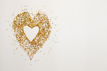 heart of gold and red sequins on a white background
