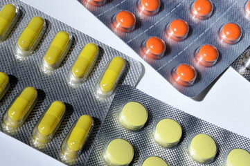 Medicine pills are packed in blisters, lie on a light background. close-up.