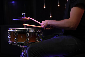 Drummer playing snare drum with sticks close up.