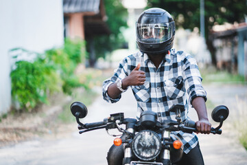 African biker in the helmet and glasses driving a motorcycle rides