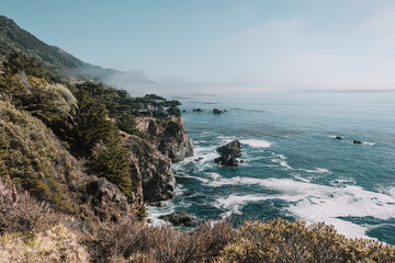 Fototapeta na wymiar View of waves crashing along the rocky California coast in Big Sur, California, USA.