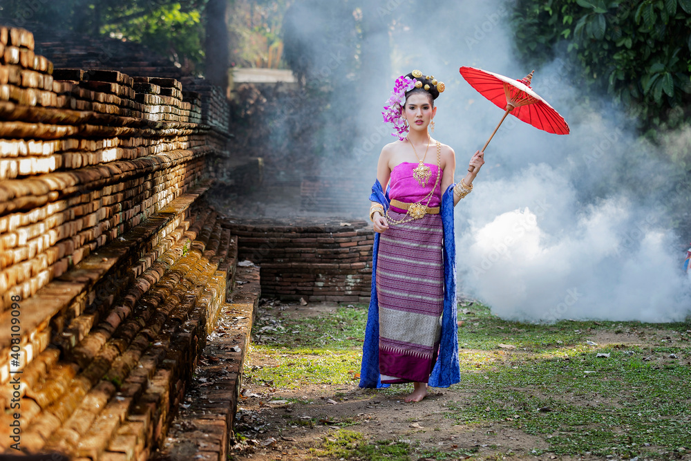 Wall mural beautiful thai woman wearing thai traditional clothing with red umbrella in amid the smoke and fog.