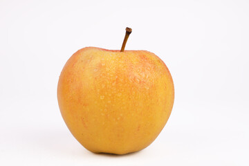yellow apple close-up with a branch on a white background