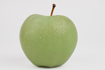 green apple close-up with a branch on a white background