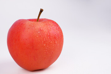 tomato-red apple with a branch on a white background