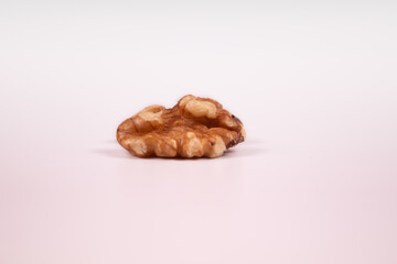 one peeled walnut half side view