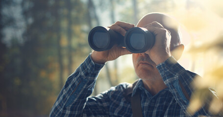 Tourist using binoculars and observing wildlife