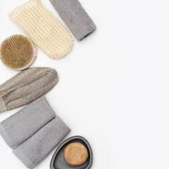 Flat lay composition with bath accessories with Soap, cotton towel, washcloth for bath, wooden comb on white