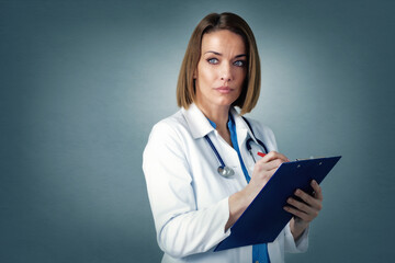 Middle aged female doctor studio portrait while standing at isolated background