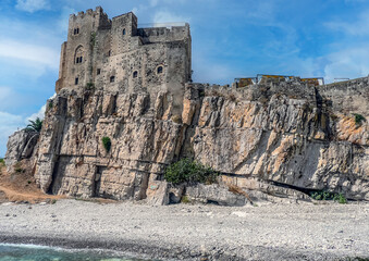 The beach of Roseto Capo Spulico with turquoise water and a castle above it