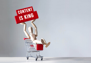 Wooden man hold a red wooden block with word Content is king ,concept