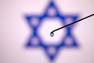 Syringe or vaccine with Israel flag in background.