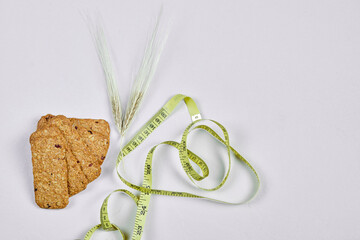 Biscuits and tape measure on a white background