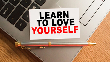 Notepad with inscriptions LEARN TO LOVE YOURSELF on a white background. business concept.