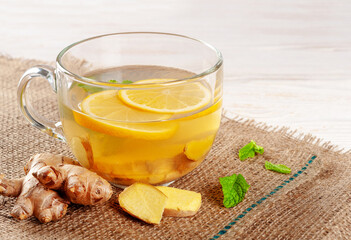 Glass cup of hot ginger tea with lemon