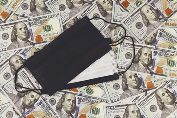 Protective mask on the background of 100 US dollars banknotes. The global financial crisis associated with the spread of coronavirus infection (COVID-19). Lockdown.