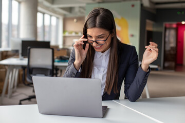 Portrait of the smiling businesswoman working at the laptop at the office.