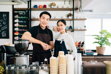 Young male and female barista cafe owner standing inside the coffee counter. Coffee making classes for entrepreneurs to start a small business. People's lifestyles during Covid-19 pandemic.