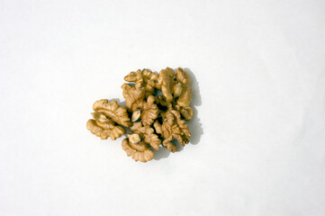 Walnut kernels on a white background, some walnuts