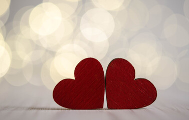 Two red wooden hearts on bokeh background