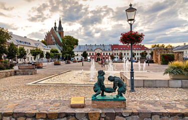 Panoramic view of Olkusz market square with St. Andrew Basilica and statue of historic Miners in Beskidy mountain region of Lesser Poland