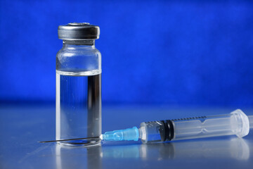Medical ampoule for injection on blue. Medicine for vaccination.