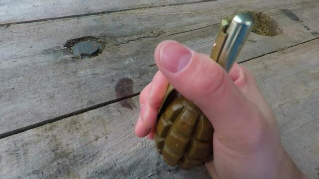 the man hand puts a Russian f-1 grenade on the table