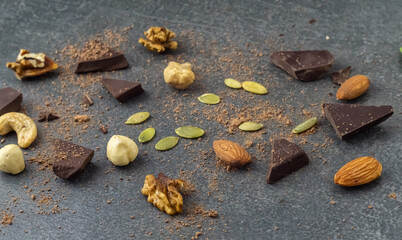 Nuts, chocolate and pumpkin seeds on the stone surface