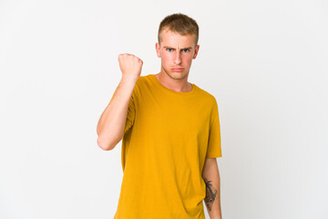 Young caucasian handsome man showing fist to camera, aggressive facial expression.