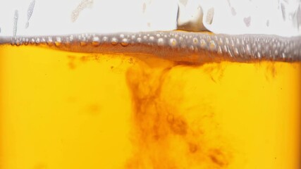 Pouring beer into glass. Closeup shot. Bubbles rising up