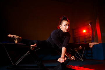 Young woman and man gymnasts do acrobatic exercises in the gym. Sports activities, Healthy lifestyle