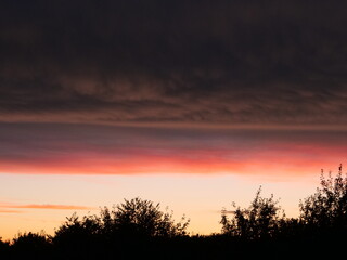 Natur pur, Wetter pur: Der Abendhimmel &uuml;ber Mecklenburg-Vorpommern nach einem abziehenden Regenschauer in den deutschen Farben Schwarz, Rot und Gold