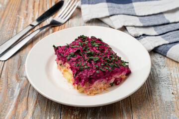 A slice of traditional russian strange meal herring under fur coat