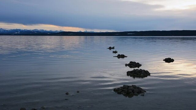 Mountain lake during sunset with a mountain range in the background. Ammersee in Bavaria during sunset.