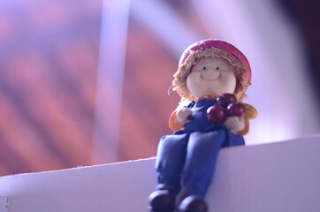 ceramic doll sitting on the wall with roof background