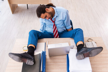 Young male employee unhappy with excessive work in the office