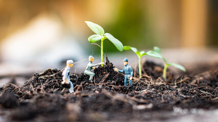 Miniature people : Nature exploration team is planting trees for a green world project. (We plant trees for a better world)