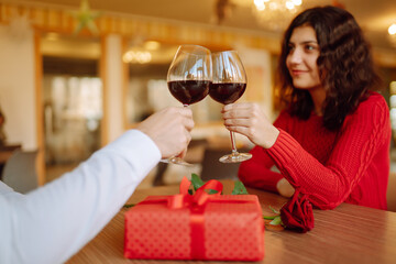 Clinking glasses with red wine. Romantic dinner. Valentines day, romantic date and holidays concept.