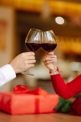 Clinking glasses with red wine. Romantic dinner. Valentines day, romantic date and holidays concept.