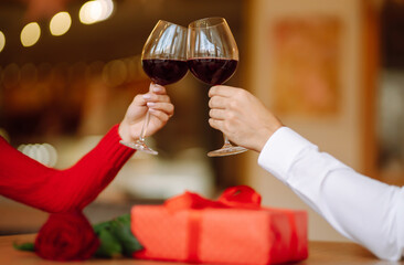 Clinking glasses with red wine. Romantic dinner. Valentines day, romantic date and holidays concept.