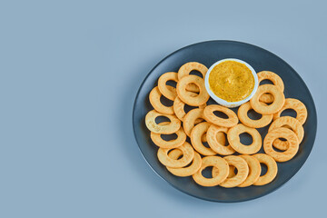 Cracker rings with a sauce on a ceramic plate